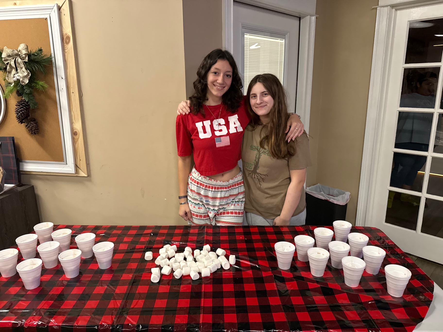 Two students serving hot cocoa at the Christmas gathering