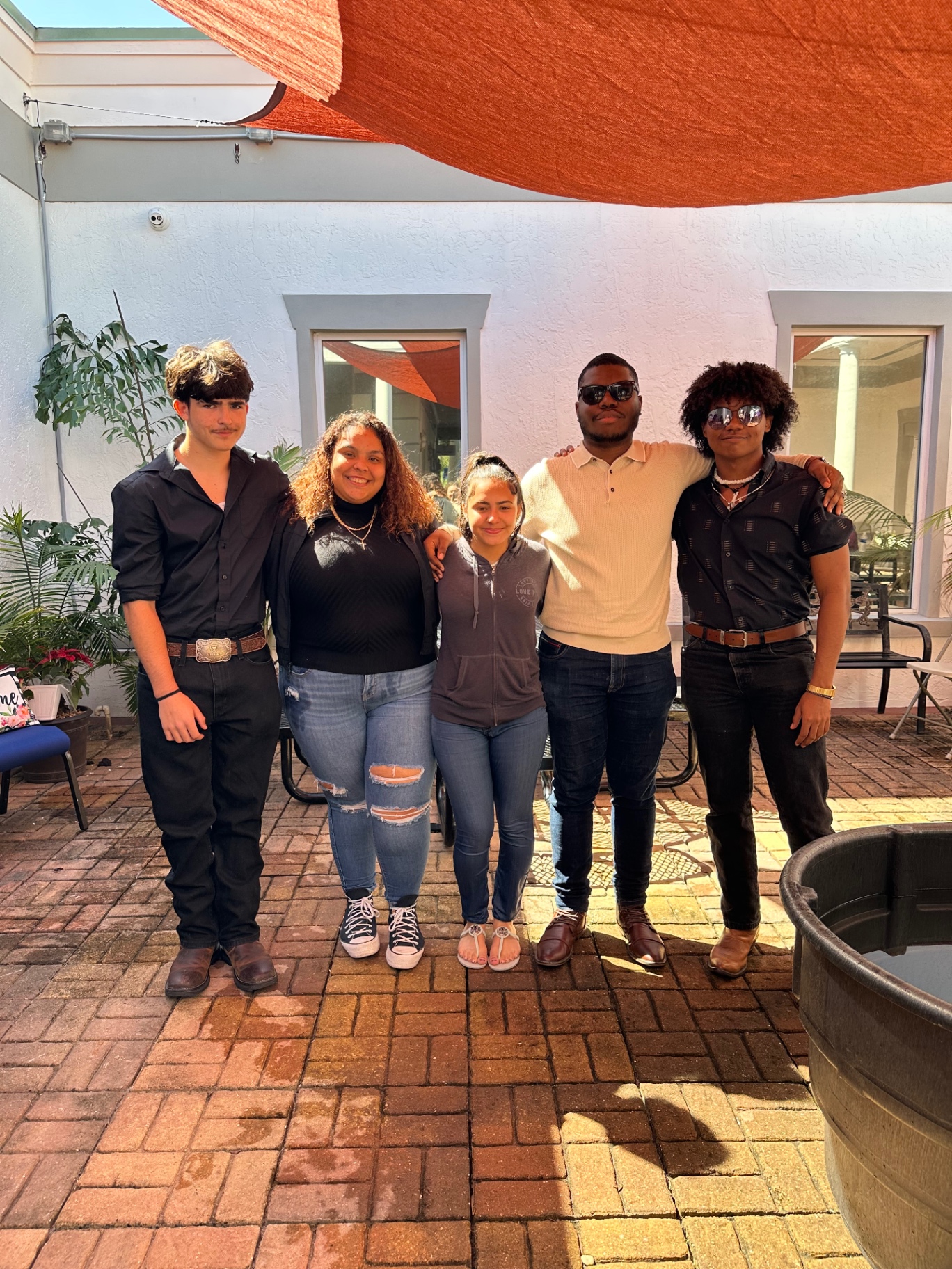 Five students together in the courtyard after a gathering