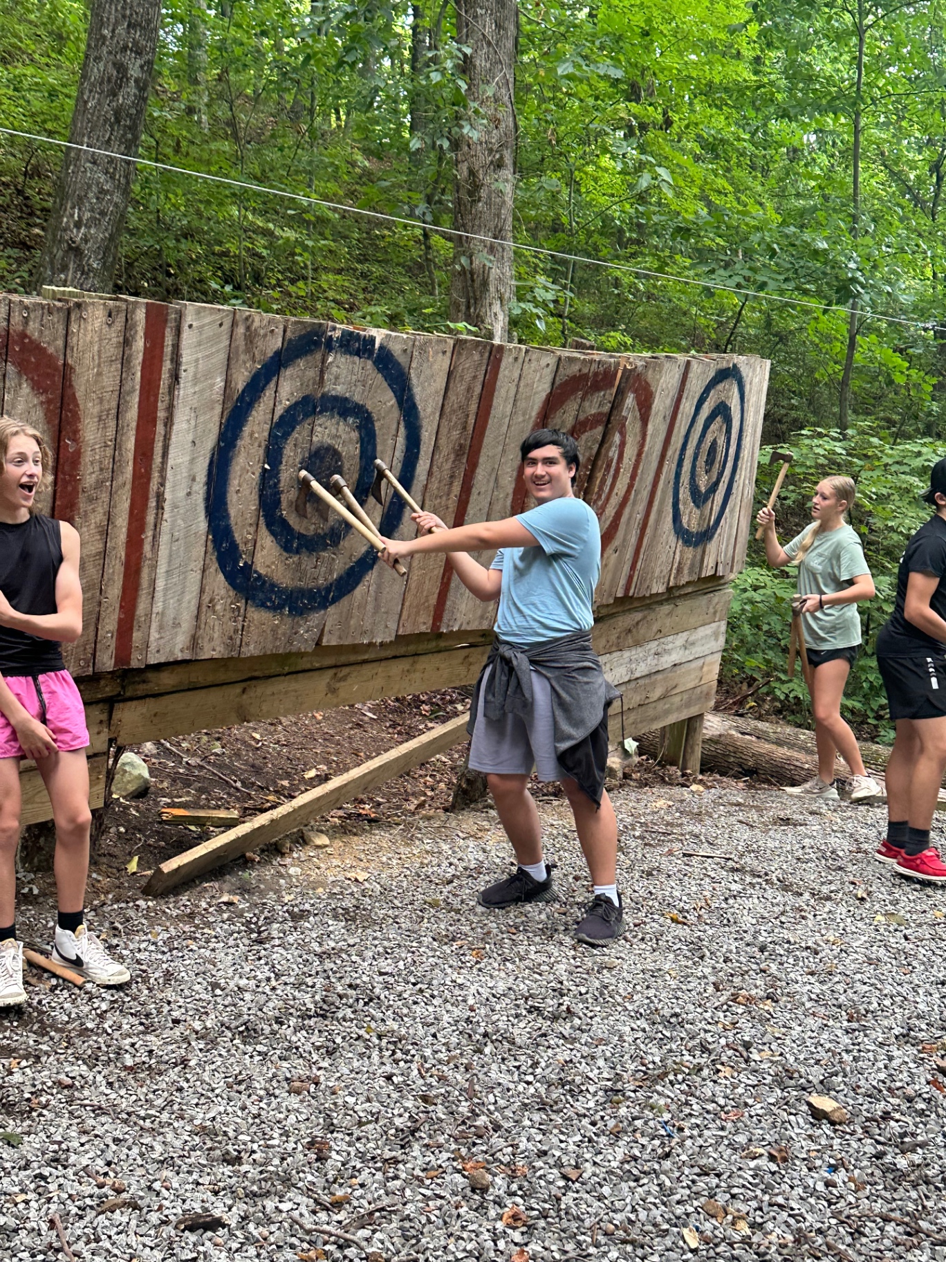 A teen trying axe throwing at a summer camp trip