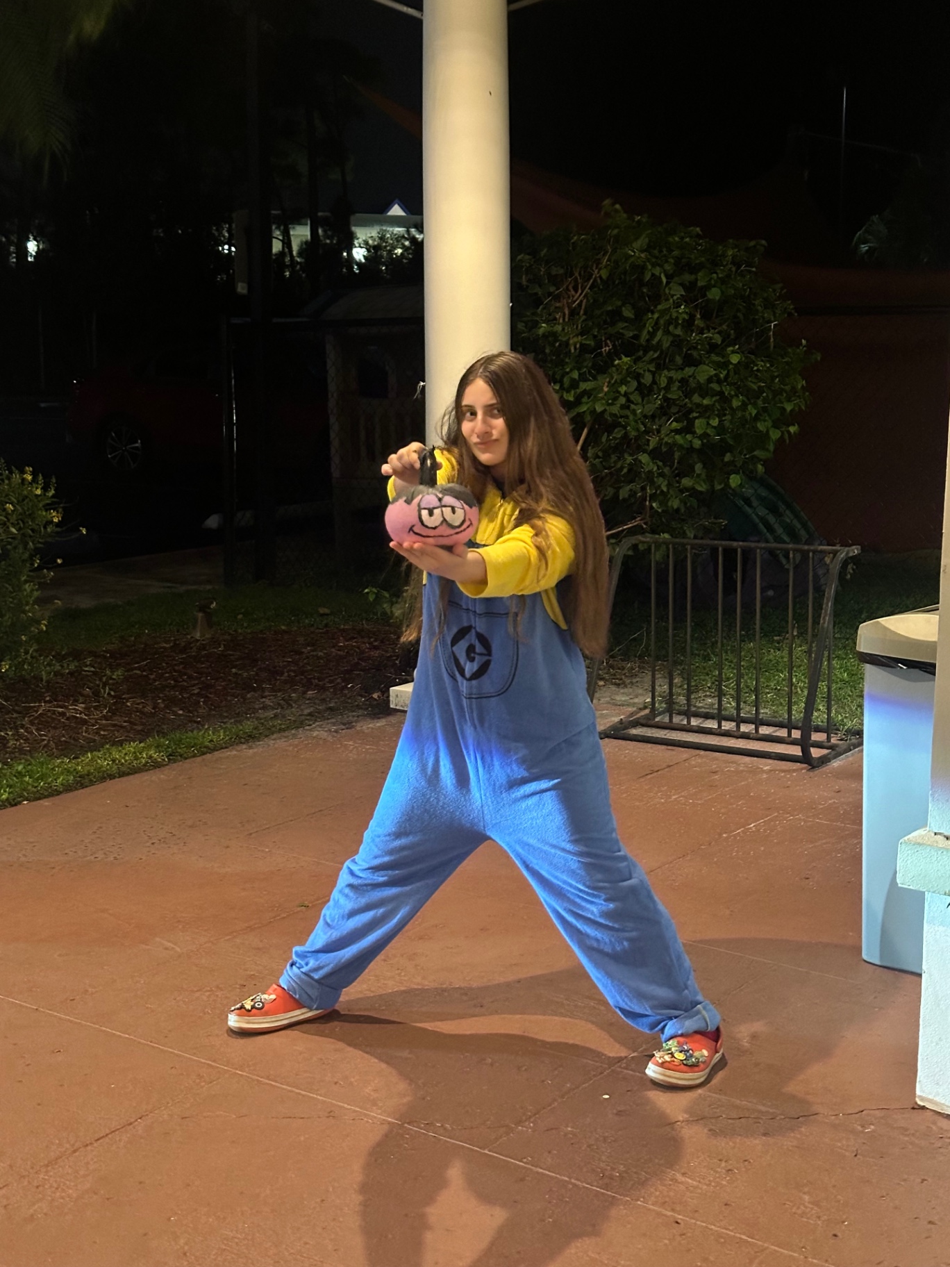 A student in a costume showing off her painted pumpkin