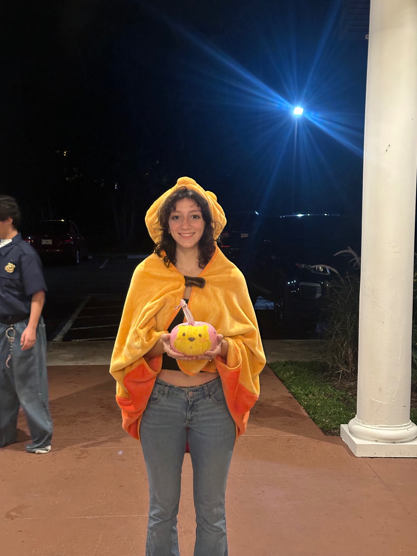 A student in costume holding a painted pumpkin at the fall gathering
