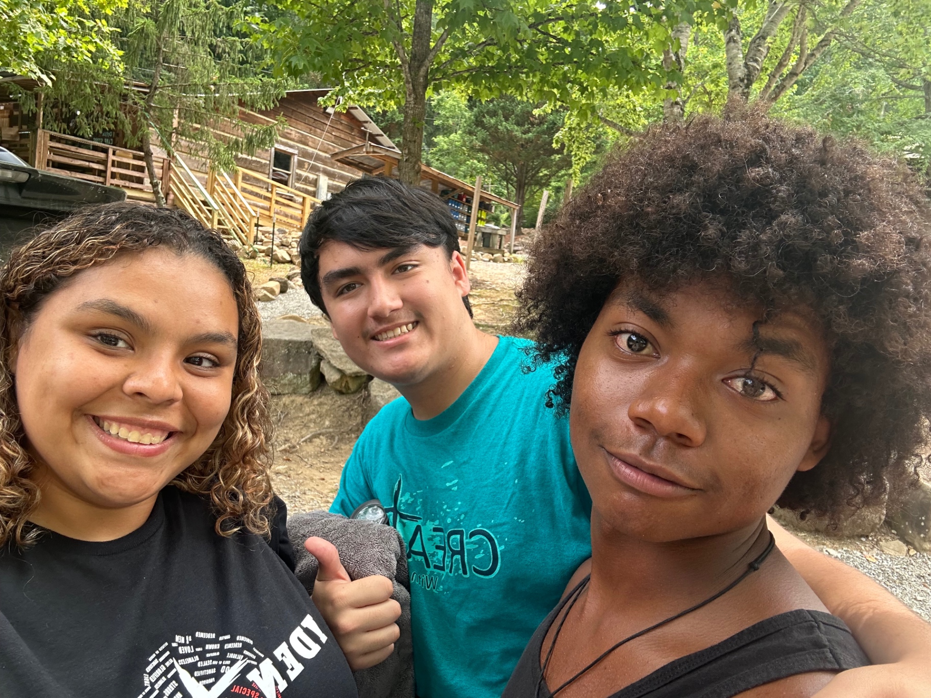 Three students smiling together at camp