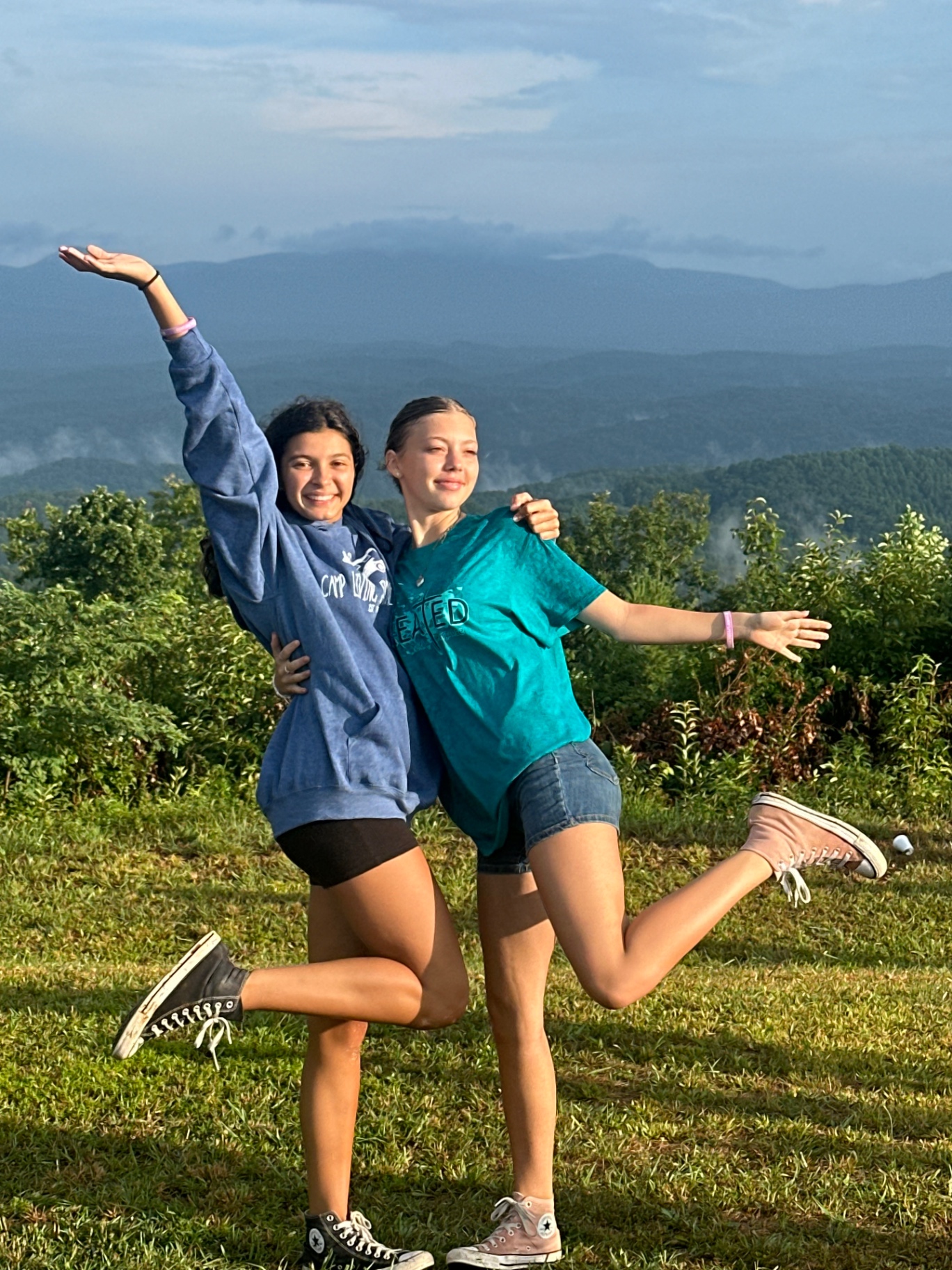 Two friends celebrating on a mountain overlook