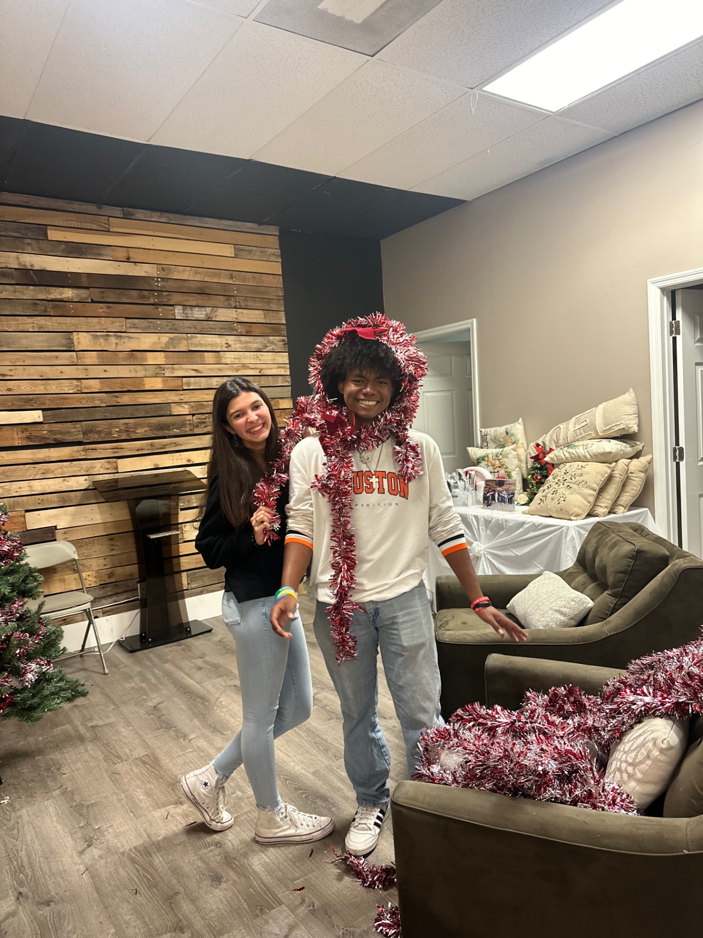 Two students decorating for Christmas with tinsel